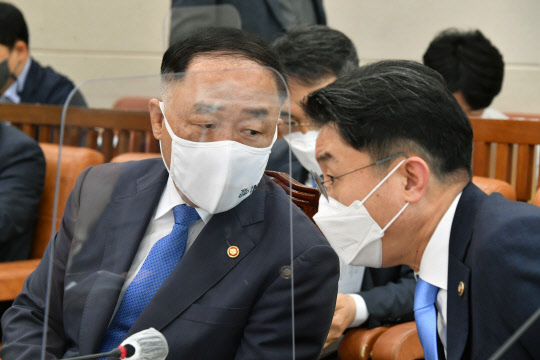 홍남기 부총리 겸 기획재정부 장관이 13일 서울 여의도 국회에서 열린 기획재정위 전체회의에서 이억원 제1차관과 대화하고 있다. 연합뉴스